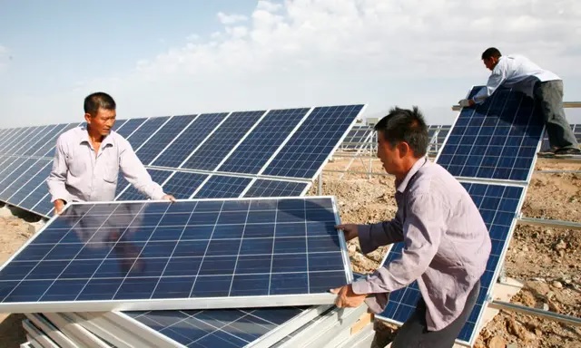 Des ouvriers installent des panneaux solaires à la centrale solaire de Hami, dans la région chinoise du Xinjiang, le 22 août 2011. (VCG/VCG via Getty Images)