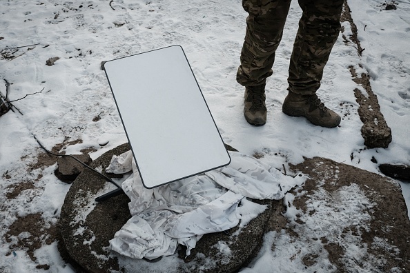 Un militaire ukrainien à côté de l'antenne du système satellitaire à large bande Starlink à Bakhmut. (Photo YASUYOSHI CHIBA/AFP via Getty Images)