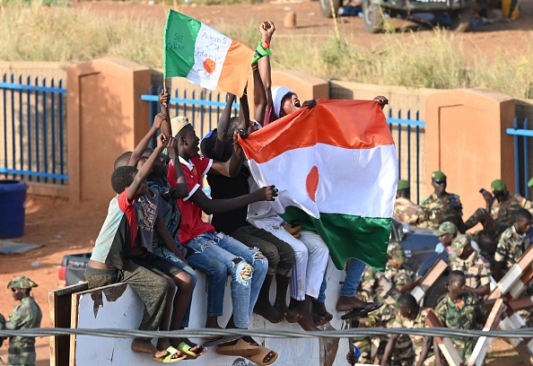 Des manifestants nigériens brandissent un drapeau national, portant l'inscription "À bas la France" devant la base aérienne nigérienne et française à Niamey, le 10 septembre 2023. (Photo AFP via Getty Images)