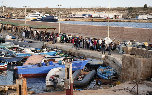 Des migrants attendent au port après leur arrivée sur l'île italienne de Lampedusa, le 18 septembre 2023.   (ZAKARIA ABDELKAFI/AFP via Getty Images)