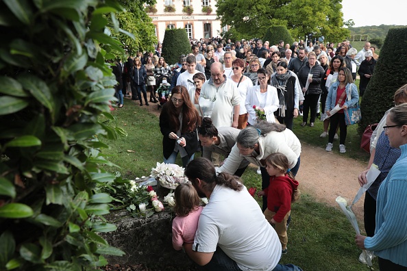 Des personnes en deuil déposent des fleurs lors d'un hommage à Lisa, 3 ans, devant la mairie de Conches-en-Ouches, le 30 septembre 2023. (Photo LOU BENOIST/AFP via Getty Images)
