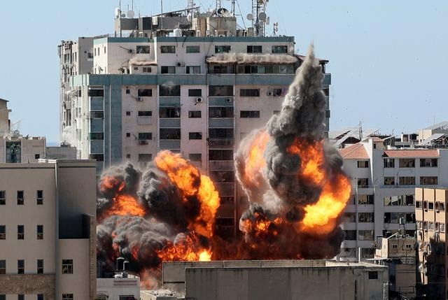 Une boule de feu jaillit de la tour Jala, détruite lors d'une frappe aérienne israélienne sur des cibles du Hamas dans la ville de Gaza, contrôlée par le groupe terroriste Hamas, le 15 mai 2021. (Mahmud Hams/AFP via Getty Images)