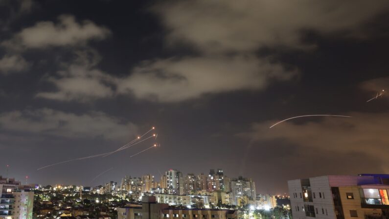 Le système de défense aérienne israélien Iron Dome (À gauche) intercepte des roquettes (À droite) lancées depuis la ville de Gaza, le 13 mai 2023, au-dessus de la ville d'Ashkelon, dans le sud du pays. (Photo by AHMAD GHARABLI / AFP) (Photo by AHMAD GHARABLI/AFP via Getty Images)