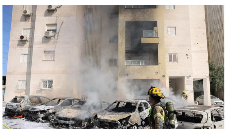 Des équipes de pompiers éteignent le feu à l'extérieur d'un immeuble résidentiel à la suite d'une attaque à la roquette depuis la bande de Gaza dans la ville d'Ashkelon, dans le sud d'Israël, le 7 octobre 2023. (Ahmad Gharabli/AFP via Getty Images)