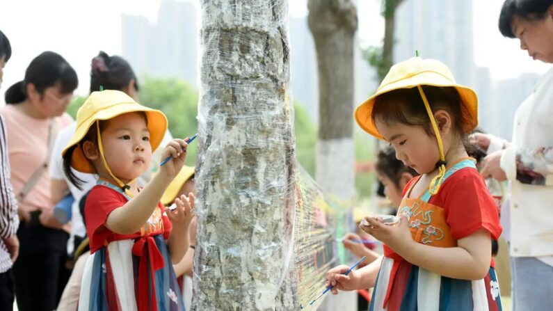 Children paint on a plastic sheet at a park on International Children's Day in Haian, in China's eastern Jiangsu Province, on June 1, 2022. (STR/AFP via Getty Images)