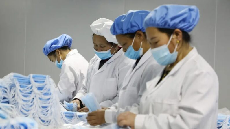 Des ouvrières fabriquent des masques de protection dans la province du Hunan (centre de la Chine), le 28 janvier 2021. (STR/AFP via Getty Images)