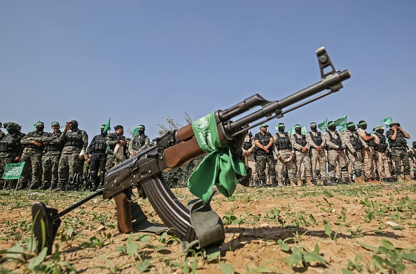Des combattants des Brigades Ezz-Al Din Al-Qassam, la branche armée du mouvement Hamas, derrière un fusil automatique. (SAID KHATIB/AFP via Getty Images)