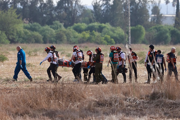 Des équipes de secours israéliennes évacuent un blessé près de la ville méridionale de Sderot le 7 octobre 2023, après que le groupe militant palestinien Hamas a lancé une attaque surprise à grande échelle contre Israël.  (MENAHEM KAHANA/AFP via Getty Images)