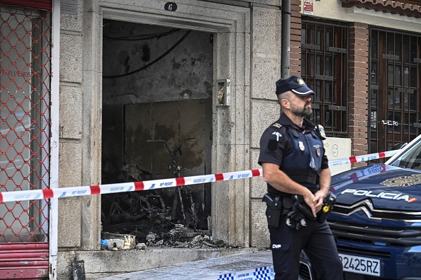 Un officier de police monte la garde à côté d'un bâtiment où quatre mineurs ont été tués dans un incendie à Vigo, le 11 octobre 2023. (Photo MIGUEL RIOPA/AFP via Getty Images)