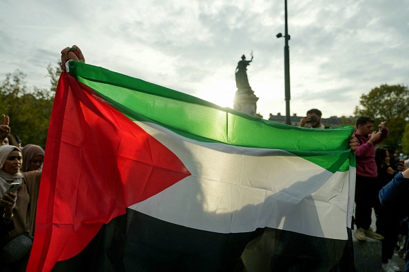 Un manifestant tient un drapeau palestinien lors d'une manifestation non autorisée de soutien aux Palestiniens, place de la République à Paris, le 12 octobre 2023.   (DIMITAR DILKOFF/AFP via Getty Images)