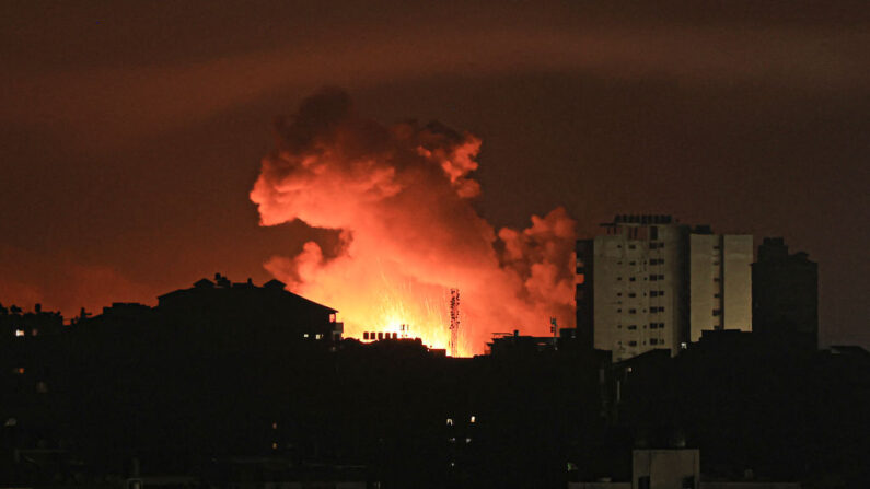 Le feu et la fumée s'élèvent au-dessus des bâtiments de la ville de Gaza lors d'une frappe aérienne israélienne, le 13 octobre 2023, alors que les combats entre Israël et le mouvement Hamas se poursuivent pour la sixième journée consécutive. (Photo MAHMUD HAMS/AFP via Getty Images)