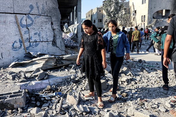 Des jeunes filles palestiniennes marchent dans les décombres après une frappe aérienne israélienne à Rafah, le 13 octobre 2023. (Photo SAID KHATIB/AFP via Getty Images)