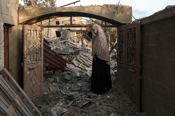 Une femme inspecte les dégâts subis par sa maison après les frappes israéliennes sur la bande de Gaza, le 14 octobre 2023. (Photo MOHAMMED ABED/AFP via Getty Images)