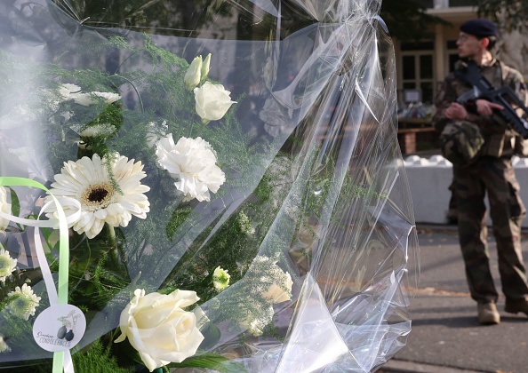 Des bouquets de fleurs déposés devant le lycée Gambetta en hommage à Dominique Bernard, professeur de français décédé lors d'une attaque au couteau le 13 octobre, à Arras.  (DENIS CHARLET/AFP via Getty Images)