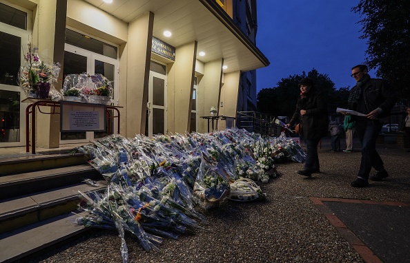 Des personnes rendent hommage au professeur de français Dominique Bernard, mort dans une attaque au couteau le 13 octobre à Arras, le 16 octobre 2023.  (DENIS CHARLET/AFP via Getty Images)