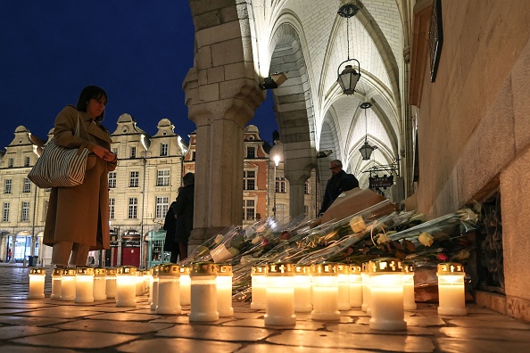 Une femme rend hommage à Dominique Bernard, professeur de français décédé lors d'une attaque au couteau, sur la place des Héros à Arras, le 16 octobre 2023. (Photo DENIS CHARLET/AFP via Getty Images)