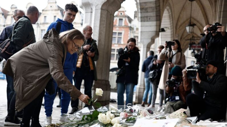 Une habitante dépose une fleur lors de la cérémonie d'enterrement de l'instituteur Dominique Bernard à la mairie d'Arras, dans le nord de la France, le 19 octobre 2023. (SAMEER AL-DOUMY/AFP via Getty Images)