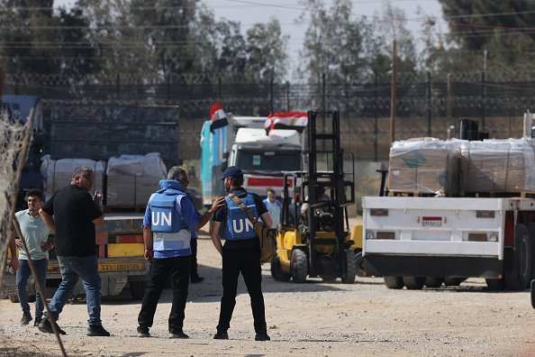 Des travailleurs humanitaires se rassemblent autour de camions transportant de l'aide humanitaire après leur entrée dans la bande de Gaza depuis l'Égypte via le poste-frontière de Rafah, le 21 octobre 2023. (Photo MOHAMMED ABED/AFP via Getty Images)