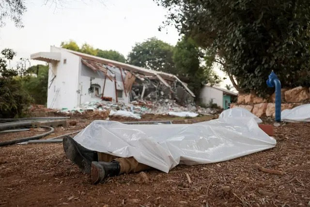 Une photo prise le 11 octobre 2023 montre des corps couverts au kibboutz Beeri près de la frontière avec Gaza, théâtre d'une attaque menée par des terroristes du Hamas quelques jours plus tôt. (Jack Guez/AFP via Getty Images)