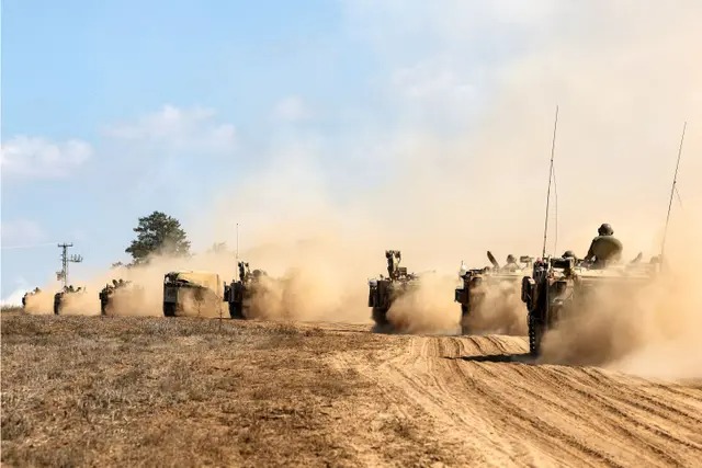 Des chars et des véhicules de l'armée israélienne se déploient le long de la frontière avec la bande de Gaza, dans le sud d'Israël, le 13 octobre 2023. (Jack Guez/AFP via Getty Images)