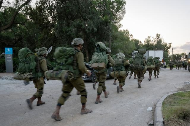 Des soldats des Forces de défense israéliennes marchent dans le kibboutz Be'eri où, quelques jours plus tôt, des terroristes du Hamas ont tué plus d'une centaine de civils près de la frontière avec Gaza, à Be'eri, en Israël, le 11 octobre 2023. (Alexi J. Rosenfeld/Getty Images)