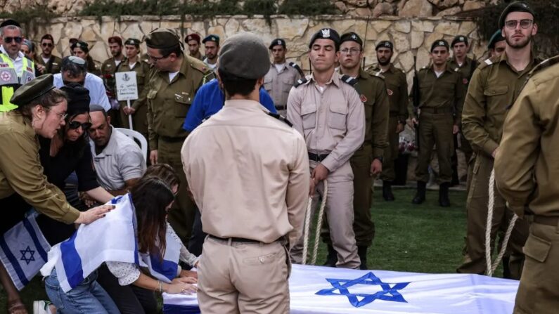 Les proches du soldat franco-israélien Eli Valentin Ghenassia, tué au combat au kibboutz Beeri lors d'une infiltration par des militants du Hamas, pleurent lors de ses funérailles au cimetière du Mont Herzl à Jérusalem, le 12 octobre 2023. (Ronaldo Schemidt/AFP/Getty Images)
