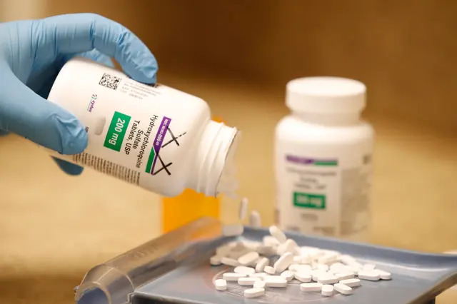 Un technicien en pharmacie verse des pilules d'hydroxychloroquine. (George Frey/AFP via Getty Images)