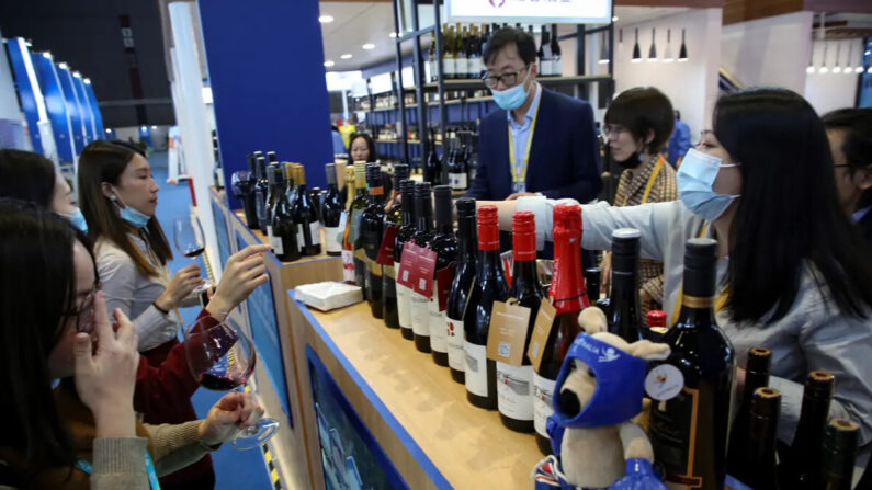 Des personnes dégustent du vin rouge d'Australie lors de l'exposition de produits alimentaires et agricoles à Shanghai, le 5 novembre 2020. (STR/AFP via Getty Images)
