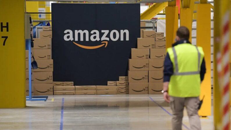 Un employé d'Amazon passe devant le logo de la société le jour de l'ouverture du nouveau centre de distribution à Augny, en France, le 23 septembre 2021. (SEBASTIEN BOZON/AFP via Getty Images)