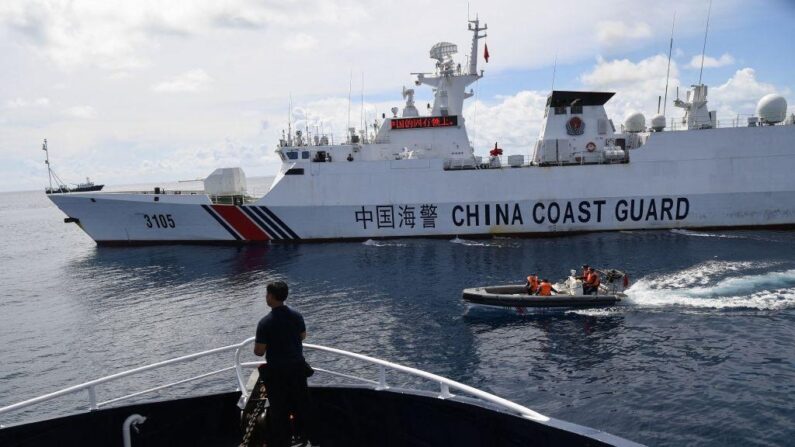 Un navire des garde-côtes chinois (à droite) bloque un navire philippin (à gauche) tandis que son personnel à bord d'un bateau pneumatique passe devant le navire philippin. (Ted Aljibe/AFP via Getty Images)