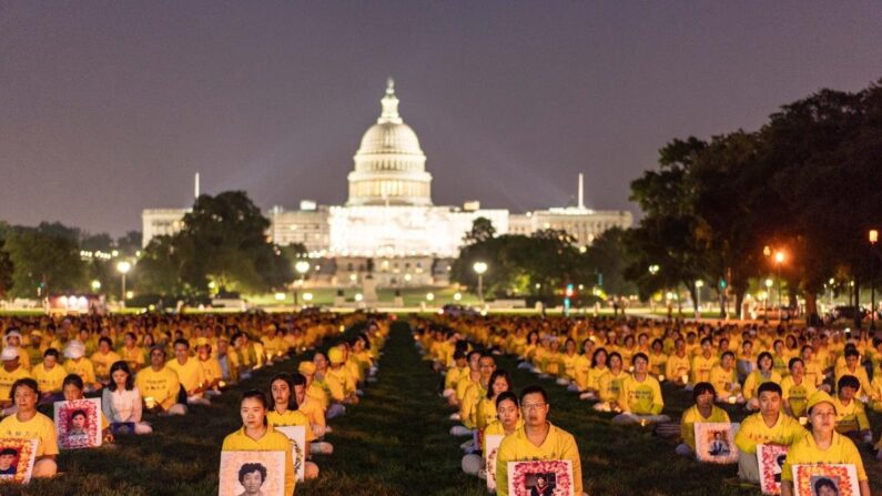 Des pratiquants du Falun Gong participent à une veillée aux chandelles à la mémoire des pratiquants du Falun Gong décédés suite aux 24 années de persécution menées par le Parti communiste chinois, sur le National Mall à Washington, le 20 juillet 2023. (Samira Bouaou/Epoch Times)