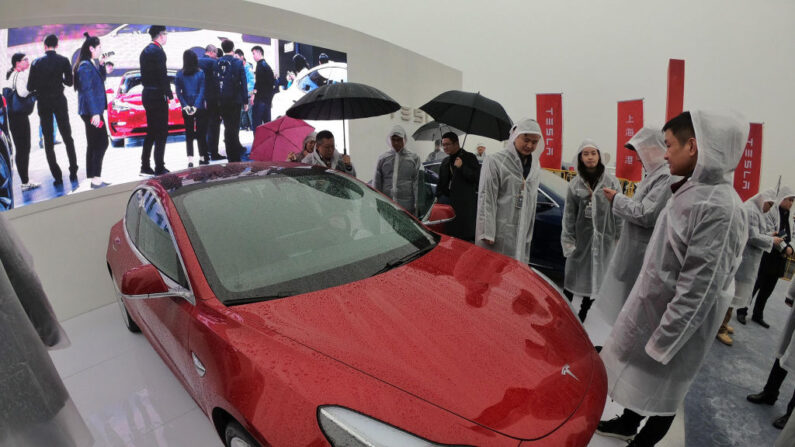 Des invités regardent une Tesla Model 3 lors d'une cérémonie d'inauguration d'une usine Tesla à Shanghai, le 7 janvier 2019. (Le crédit photo doit se lire STR/AFP via Getty Images)