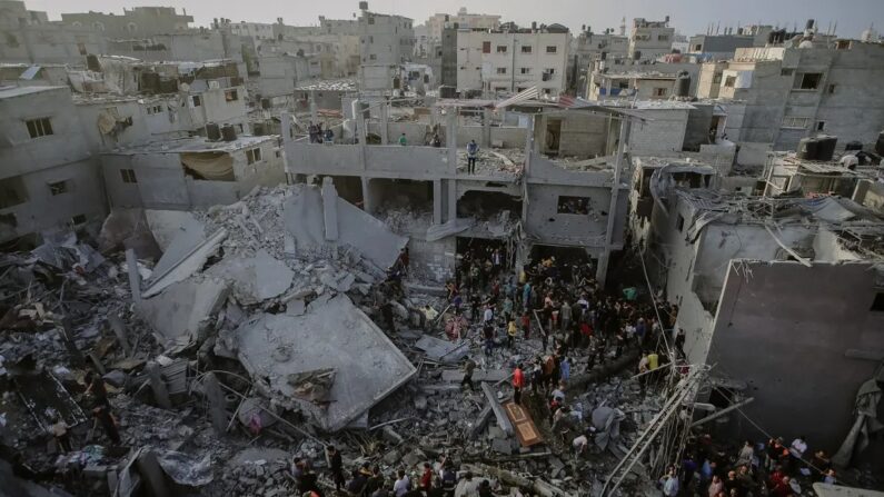 Des civils palestiniens et équipes de secours fouillent les débris d'un bâtiment détruit à Al-Maghazi, dans le centre de la bande de Gaza, à la recherche de survivants et de victimes suite au bombardement israélien, le 5 novembre 2023. (Mohammed Zaanoun/Middle East Images/AFP via Getty Images)
