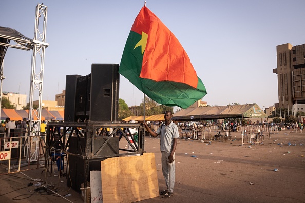 Un homme tient un drapeau du Burkina lors d'un rassemblement de soutien à l'armée à Ouagadougou, le 19 février 2022. (Photo OLYMPIA DE MAISMONT/AFP via Getty Images)