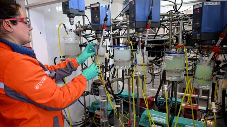 Un technicien manipule un appareil avec lequel on sépare en laboratoire le Nickel et le lithium après les avoir collectés dans les batteries de voitures électriques recyclées, au siège du groupe minier Eramet, à Trappes le 16 mars 2023. (Photo EMMANUEL DUNAND/AFP via Getty Images)