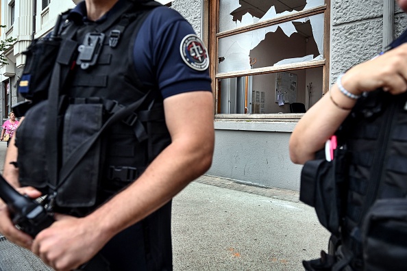 Des policiers devant un commissariat endommagé à Lyon, à la suite du meurtre de Nahel, le 1er juillet 2023. (Photo OLIVIER CHASSIGNOLE/AFP via Getty Images)