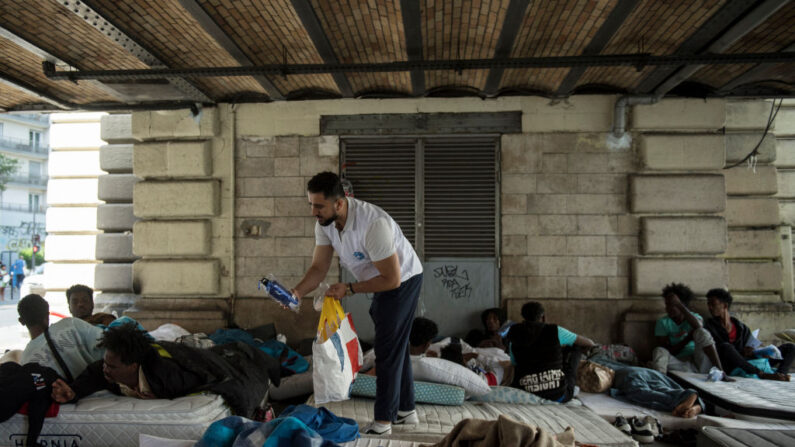 Un bénévole de Médecins du Monde, dans le camp de migrants du quartier Stalingrad à Paris, le 12 juillet 2023. (Photo JULIEN DE ROSA/AFP via Getty Images)