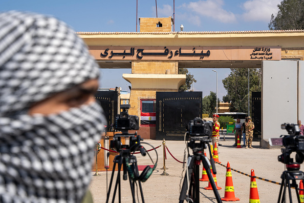 Un manifestant pro-palestinien se tient derrière des caméras installées par des membres des médias, à la frontière avec la bande de Gaza, le 20 octobre 2023. (Photo ALI MOUSTAFA/AFP via Getty Images)