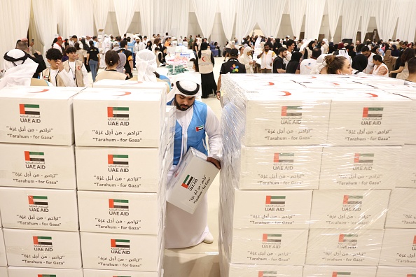 Des bénévoles aident à emballer l'aide destinée à la bande de Gaza dans un centre de dons mis en place par le Croissant-Rouge des Émirats à Dubaï, le 21 octobre 2023. (Photo KARIM SAHIB/AFP via Getty Images)