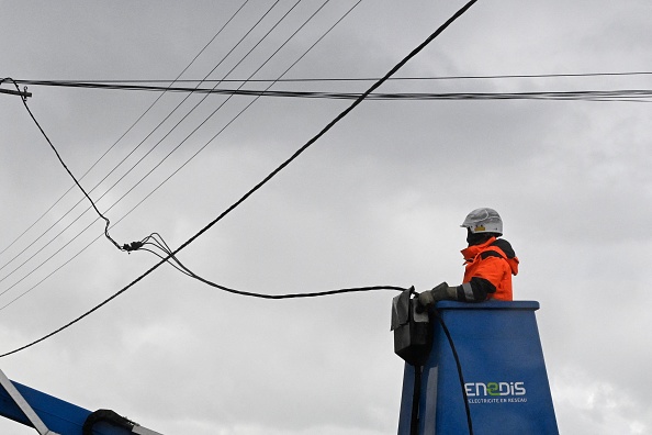 Un salarié d'Enedis travaille sur des câbles électriques à Lanildut, le 2 novembre 2023, alors que la tempête Ciaran frappe la région. (Photo DAMIEN MEYER/AFP via Getty Images)