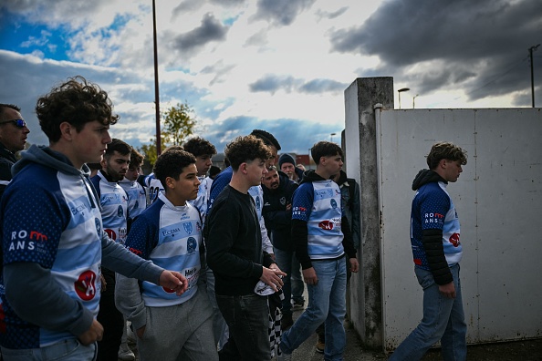 Des membres du club de rugby RC Romans-Peage participent à la Marche Blanche à Romans-sur-Isere, le 22 novembre 2023, pour rendre hommage à Thomas, un adolescent tué le 19 novembre 2023 à Crépol.  (OLIVIER CHASSIGNOLE/AFP via Getty Images)