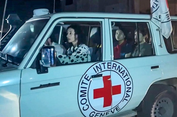 Cette image extraite d'une vidéo AFPTV montre un véhicule de la Croix-Rouge internationale transportant des otages libérés par l'organisation terroriste Hamas qui traverse le poste frontière de Rafah dans la bande de Gaza en direction de l'Égypte. (Photo MAHMUD HAMS/AFPTV/AFP via Getty Images)