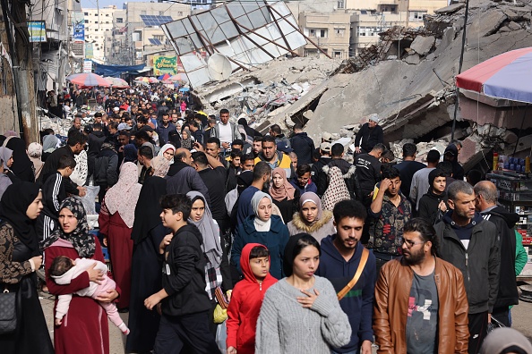 Une foule de personnes passe devant des bâtiments détruits dans la ville de Khan Yunis, au sud de la bande de Gaza, le 28 novembre 2023. (Photo MOHAMMED ABED/AFP via Getty Images)