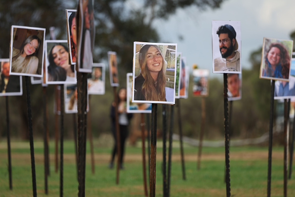 Des photos de victimes du festival de musique Noval se trouvent sur le site du massacre du 7 octobre près du kibboutz Re'im et de la frontière avec Gaza, le 28 novembre 2023. (Photo Spencer Platt/Getty Images)