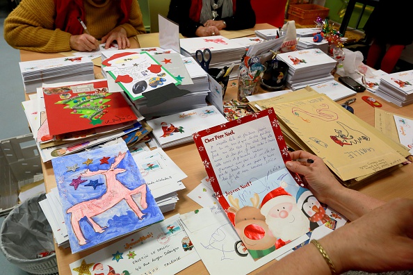 Des employés de La Poste lisent les lettres de Noël envoyées par les enfants au Père Noël. (Photo NICOLAS TUCAT/AFP via Getty Images)