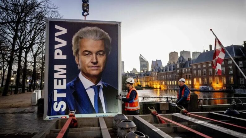 Des ouvriers se préparent à enlever une pancarte électorale du leader du Parti pour la liberté (PVV) Geert Wilders près du Binnenhof, au lendemain des élections générales néerlandaises, à La Haye, le 23 novembre 2023. (Robin Utrecht/ANP/AFP via Getty Images)