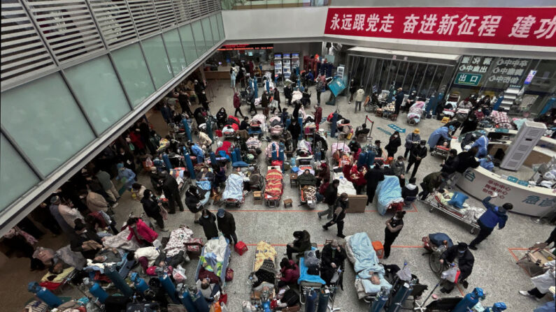 Des patients sont soignés par des membres de leur famille et du personnel médical sur des lits installés dans l'atrium d'un hôpital très fréquenté, le 13 janvier 2023 à Shanghai, en Chine. (Kevin Frayer/Getty Images)