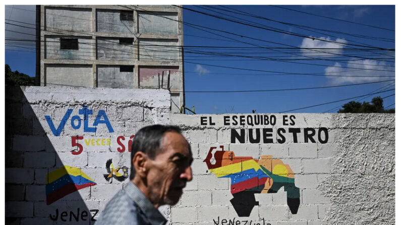Un homme passe devant une peinture murale qui promeut un référendum proposant aux Vénézuéliens d'envisager l'annexion de la région d'Essequibo, administrée par le Guyana, à Caracas, au Venezuela, le 28 novembre 2023. (Federico Parra/AFP via Getty Images)