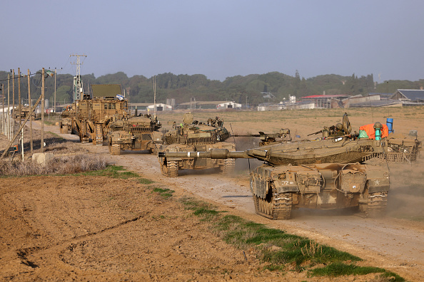 Des chars militaires israéliens roulent près de la frontière avec la bande de Gaza le 3 décembre 2023. (Photo MENAHEM KAHANA/AFP via Getty Images)