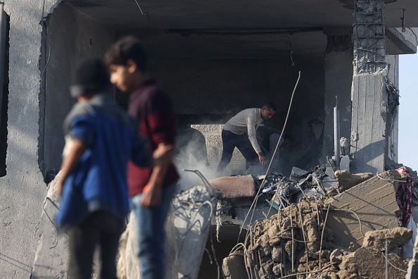 Un Palestinien inspecte les dommages subis par un immeuble résidentiel à Rafah, dans le sud de la bande de Gaza, à la suite de frappes aériennes israéliennes, le 4 décembre 2023. (Photo MOHAMMED ABED/AFP via Getty Images)